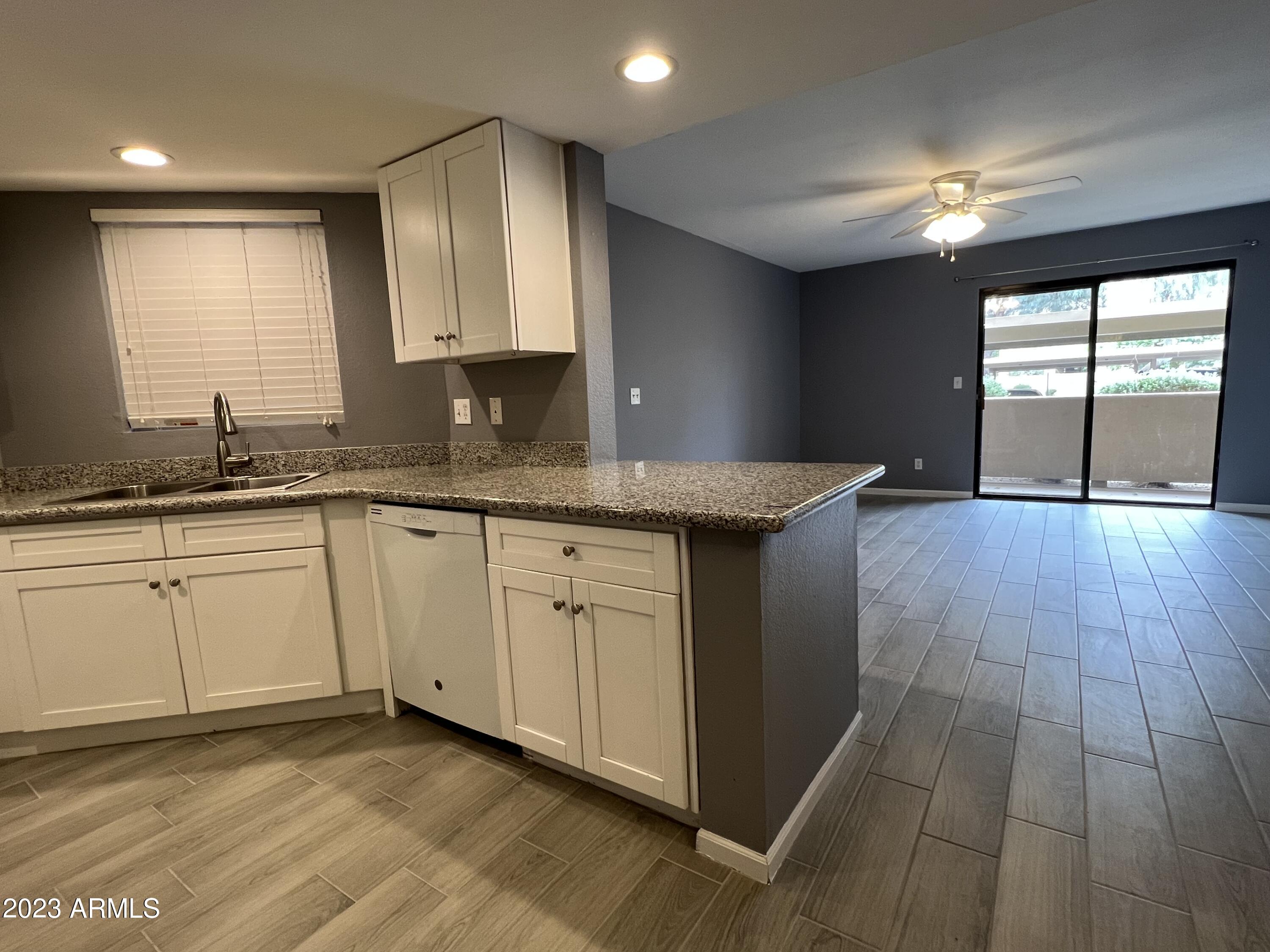 4850 East Desert Cove Avenue, Unit 105 Scottsdale, AZ 85254 - Photo 2 of 12 a kitchen with a sink cabinets and window