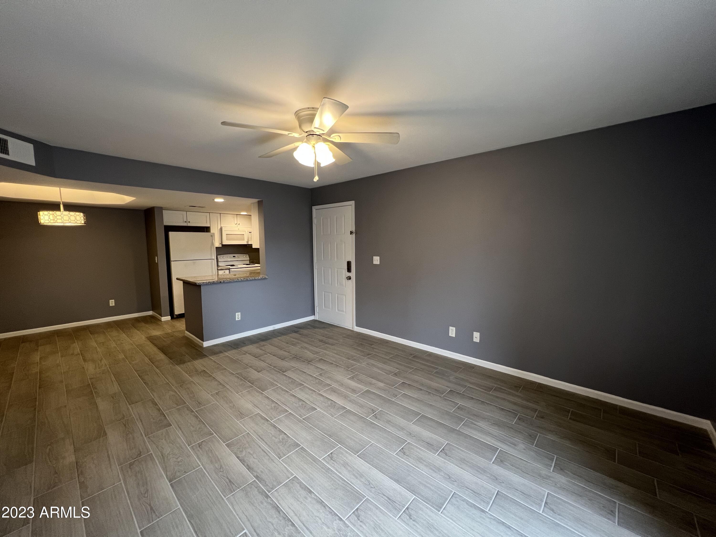 4850 East Desert Cove Avenue, Unit 105 Scottsdale, AZ 85254 - Photo 3 of 12 wooden floor in an empty room with a window
