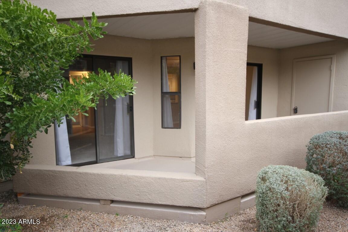 4850 East Desert Cove Avenue, Unit 105 Scottsdale, AZ 85254 - Photo 9 of 12 a potted plant sitting in front of a house