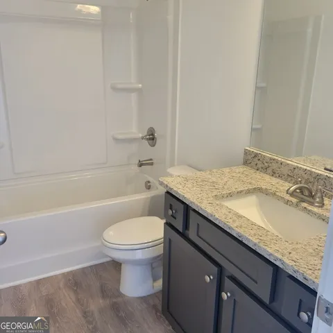 a bathroom with a granite countertop toilet a sink and bathtub