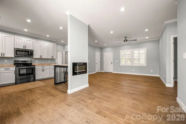 a view of kitchen with kitchen island microwave and stove top oven