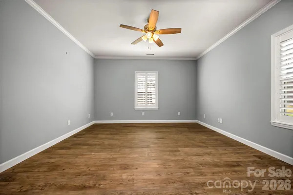 an empty room with window and ceiling fan
