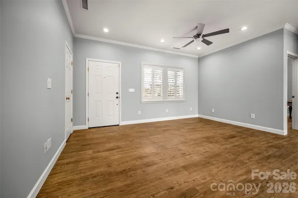 an empty room with windows and ceiling fan