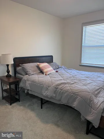 a bed sitting in a bedroom next to a window
