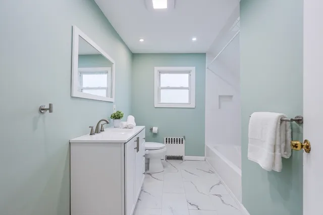 a bathroom with a toilet sink and mirror
