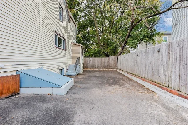 a view of a house with a backyard and wooden fence