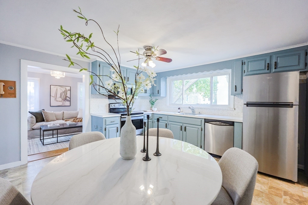 3 Vinal Street Somerville, MA 02145 - Photo 5 of 29 a kitchen with stainless steel appliances granite countertop a dining table chairs and chandelier