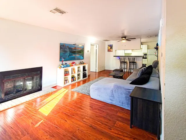 a bedroom with a bed and a flat tv screen on dresser