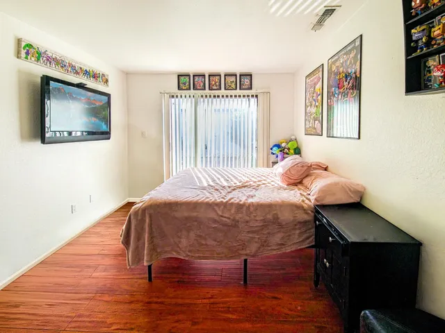 a bedroom with a bed and a painting on the wall