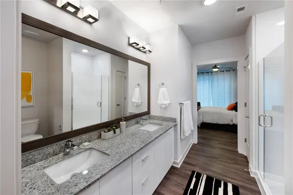a bathroom with a granite countertop double vanity sink and a mirror