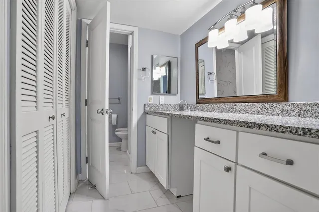 a bathroom with a granite countertop sink vanity and mirror