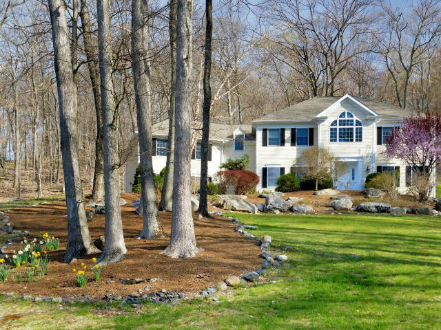 151 Ledges Road Ridgefield, CT 06877 - Photo 2 of 24 a front view of a house with a garden and trees