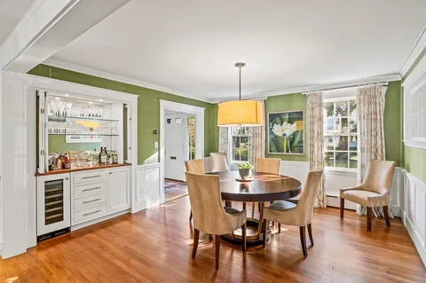 a dining room with furniture a chandelier and wooden floor