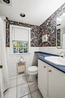 a bathroom with a toilet sink and mirror