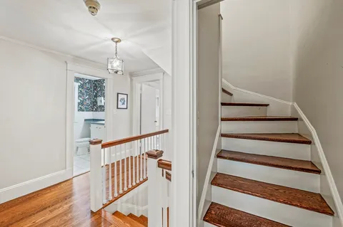 a view of staircase with wooden floor and white walls