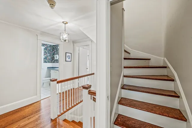 a view of staircase with wooden floor and white walls