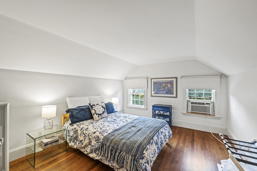 19 Elmwood Road Marblehead, MA 01945 - Photo 26 of 36 a bedroom with a large bed a fireplace and wooden floor
