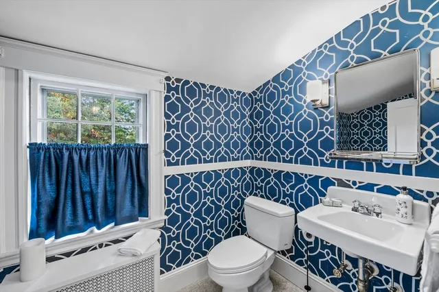 a bathroom with a toilet a sink and a window