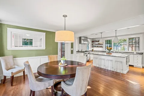 a dining room with furniture a window and wooden floor