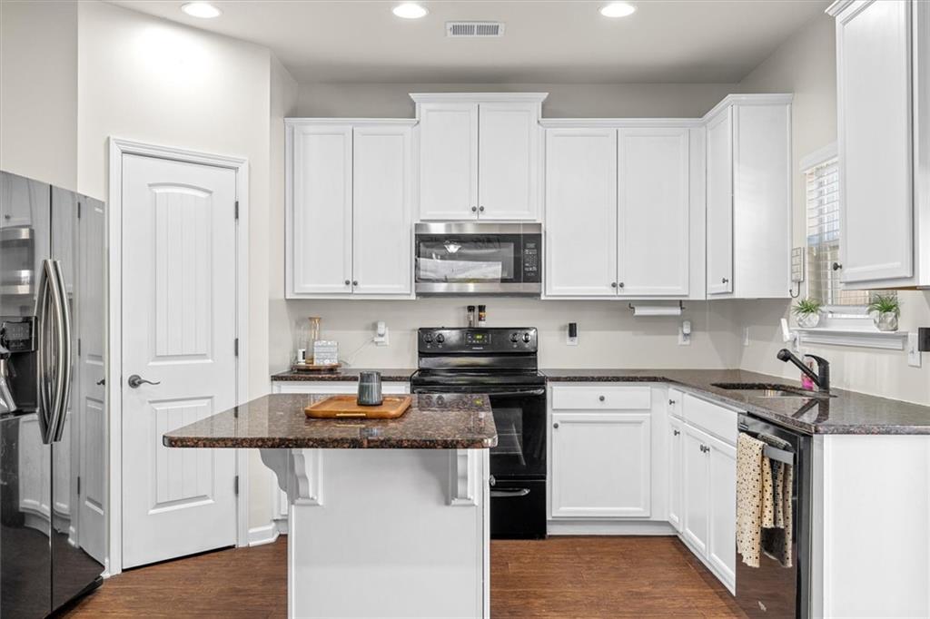 329 Rippling Drive Ball Ground, GA 30107 - Photo 13 of 43 a kitchen with stainless steel appliances granite countertop a stove a sink and a refrigerator