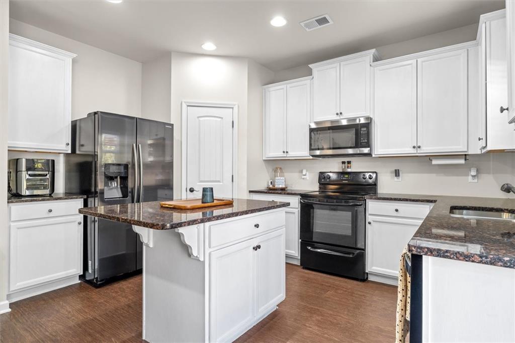 329 Rippling Drive Ball Ground, GA 30107 - Photo 15 of 43 a kitchen with stainless steel appliances granite countertop a stove top oven a sink and a refrigerator