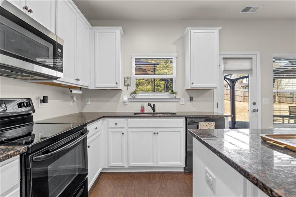 329 Rippling Drive Ball Ground, GA 30107 - Photo 16 of 43 a kitchen with granite countertop a sink stainless steel appliances and cabinets