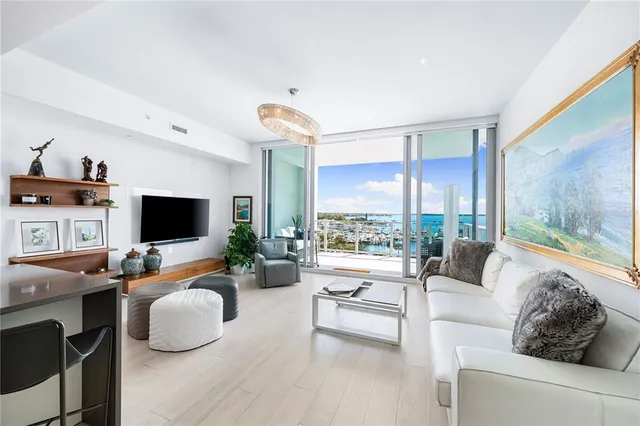 a living room with furniture a clock and a view of kitchen