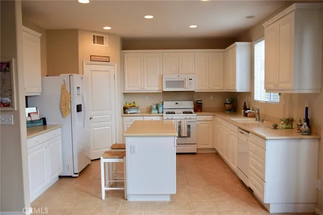 a kitchen with white cabinets and refrigerator