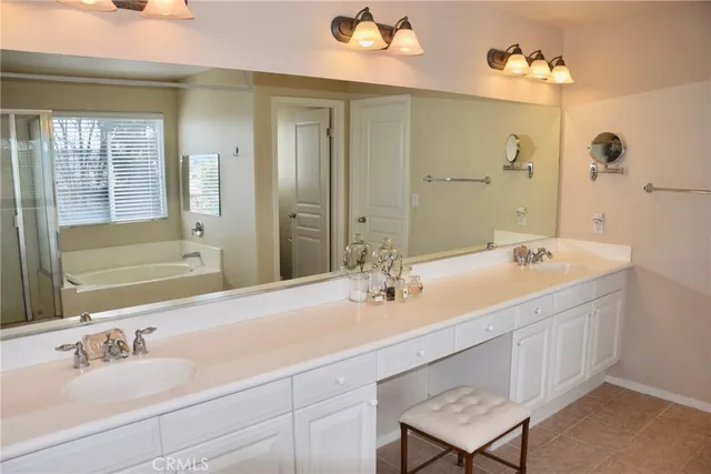 a bathroom with a double vanity sink a mirror and a bathtub