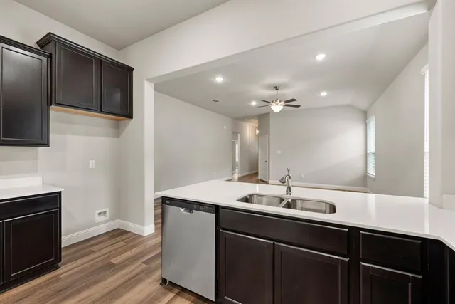 a kitchen with stainless steel appliances granite countertop a sink and wooden cabinets
