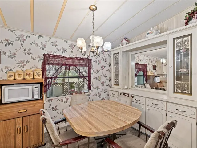 a spacious bedroom with a bed a chandelier and large window