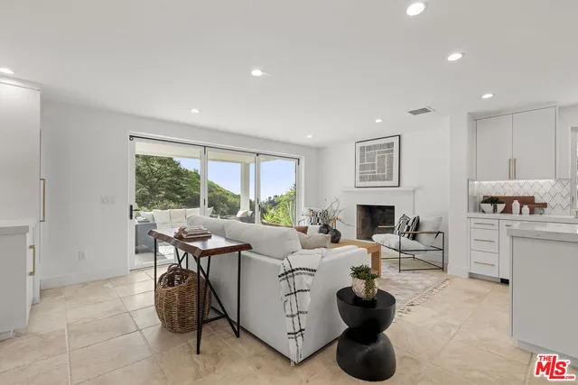 a living room with furniture a large window and a fireplace