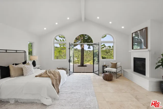 a spacious bedroom with a bed and glass windows