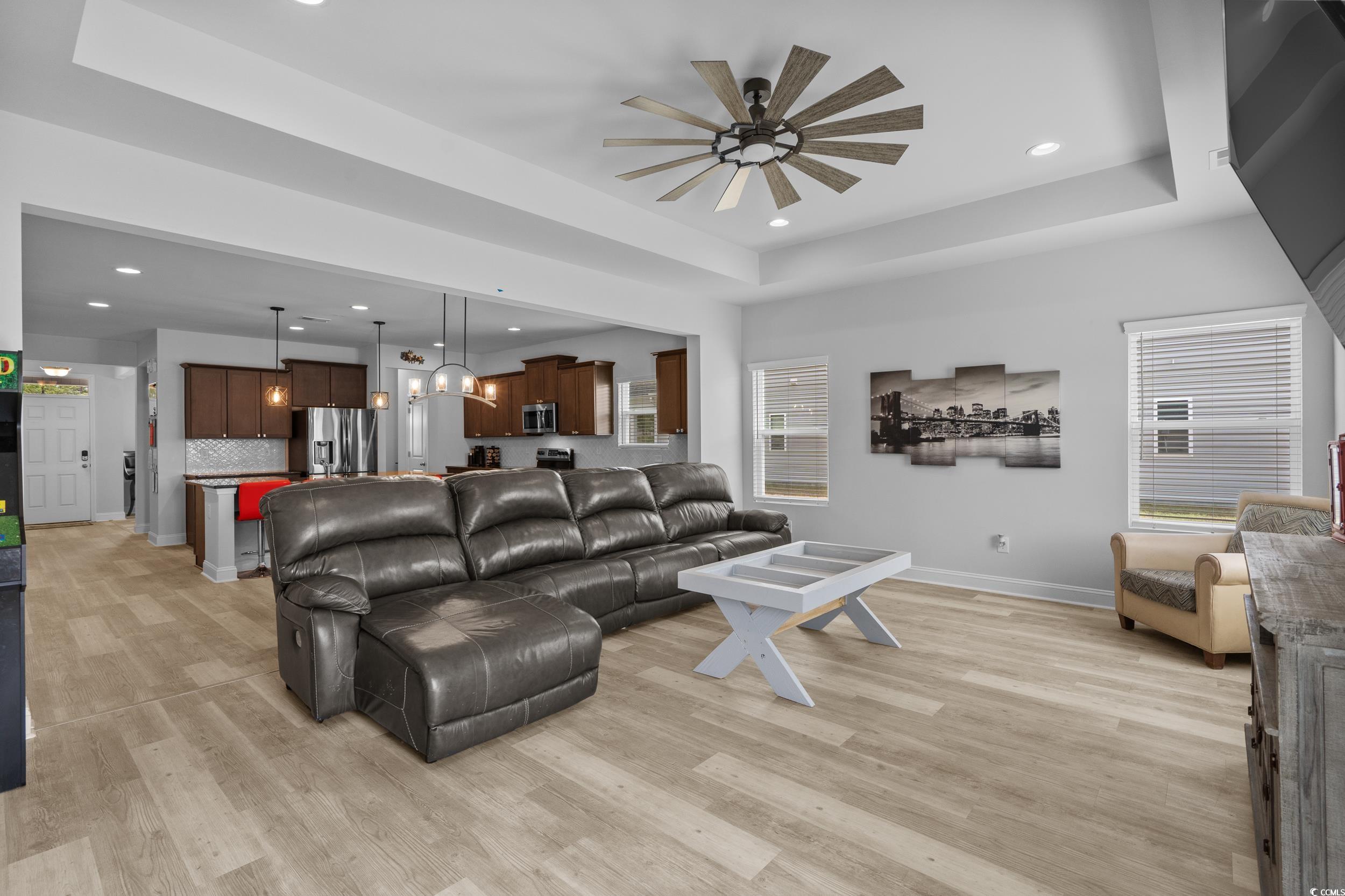 2064 Hazlette Loop Conway, SC 29526 - Photo 13 of 39 Living area featuring baseboards, a tray ceiling, light wood-style floors, and a ceiling fan