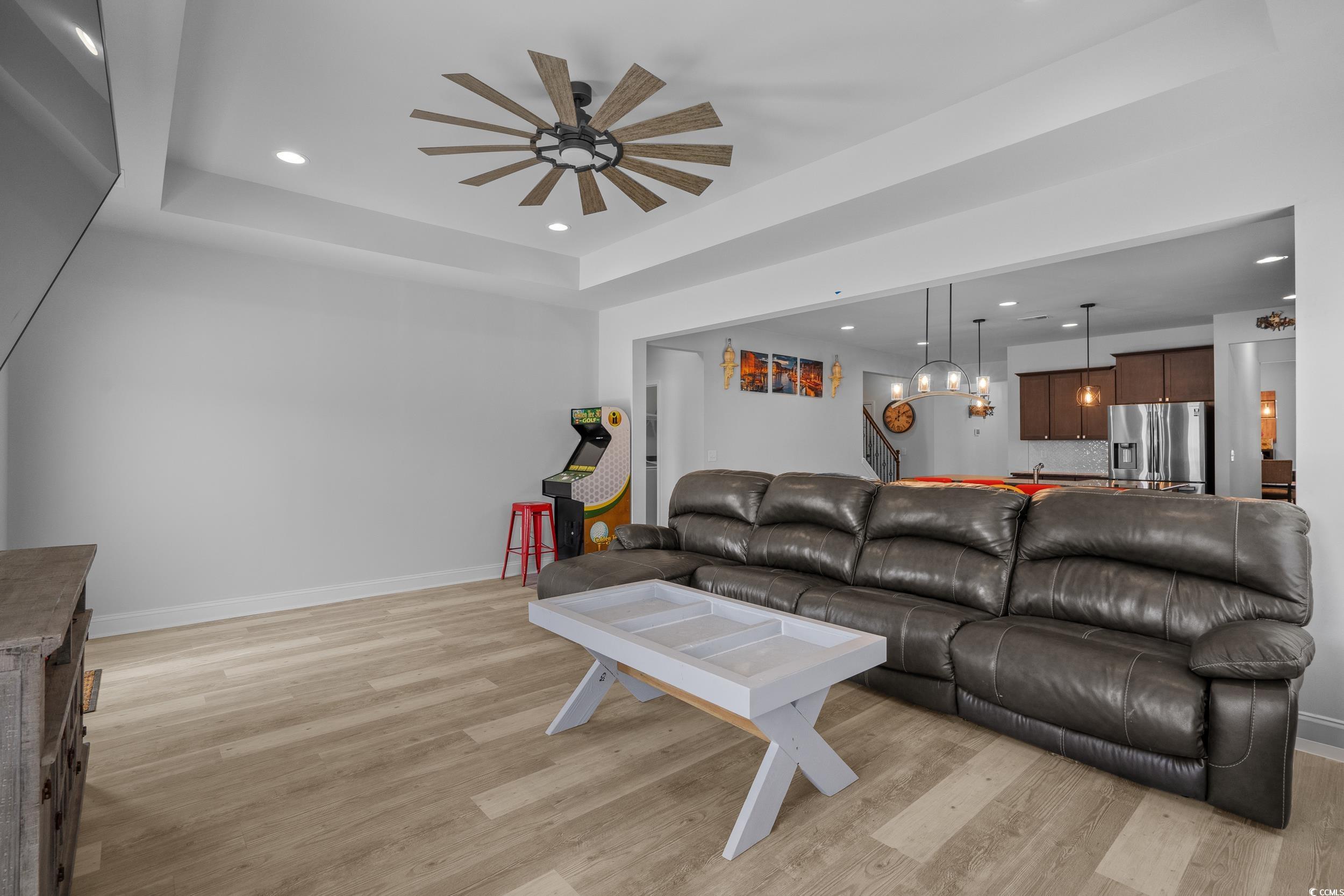 2064 Hazlette Loop Conway, SC 29526 - Photo 14 of 39 Living area with a tray ceiling, light wood finished floors, ceiling fan with notable chandelier, baseboards, and recessed lighting