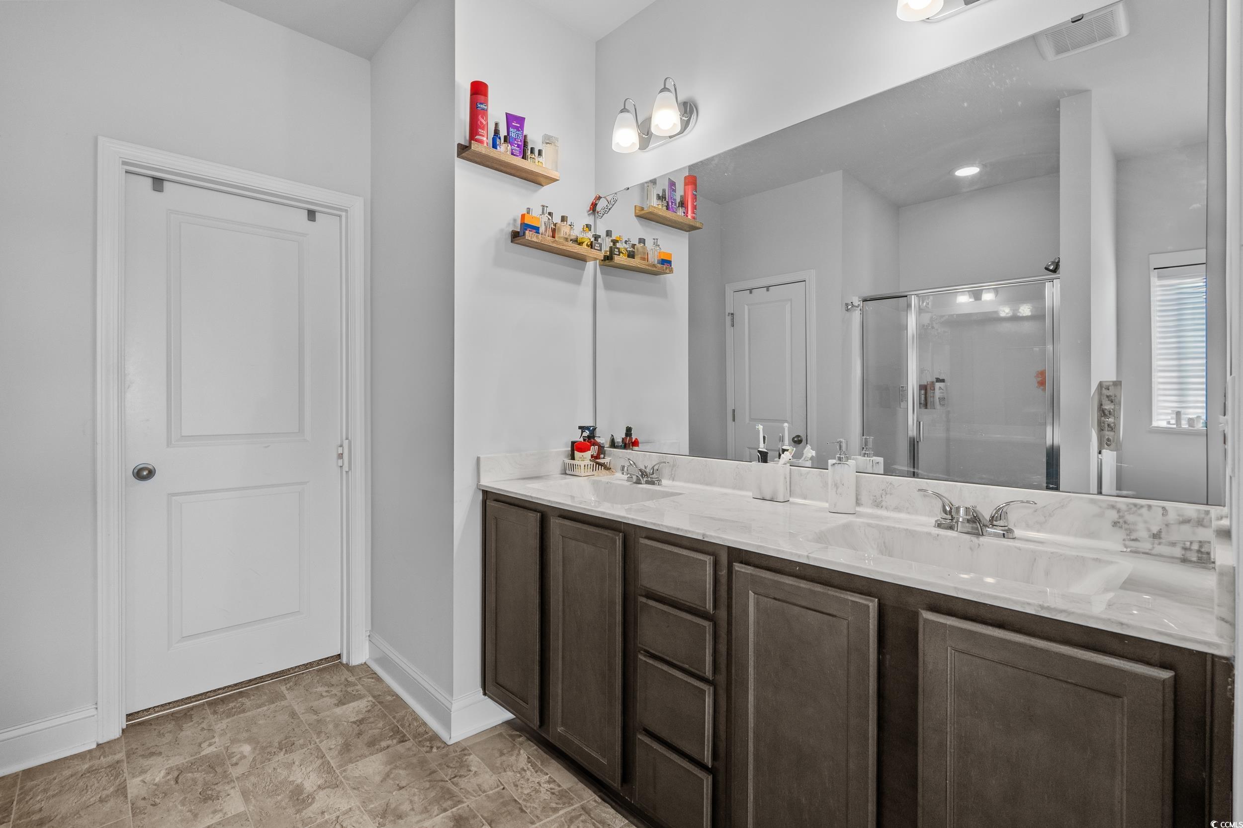 2064 Hazlette Loop Conway, SC 29526 - Photo 26 of 39 Full bathroom featuring a sink, a shower stall, baseboards, visible vents, and double vanity