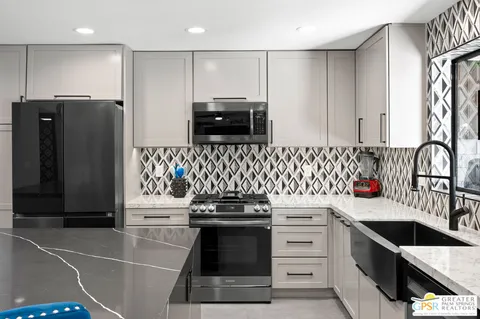 a kitchen with stainless steel appliances a stove a sink and a refrigerator