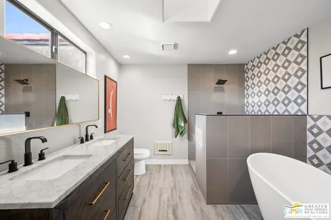 a bathroom with a sink a toilet and a mirror