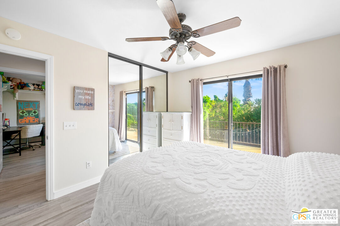 28220 Horizon Road Cathedral City, CA 92234 - Photo 30 of 40 a bedroom with a large bed and a chandelier