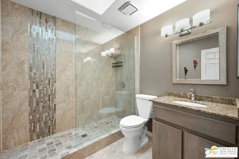 a bathroom with a granite countertop sink toilet and shower