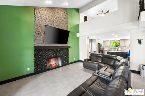 a living room with furniture a fireplace and a flat screen tv