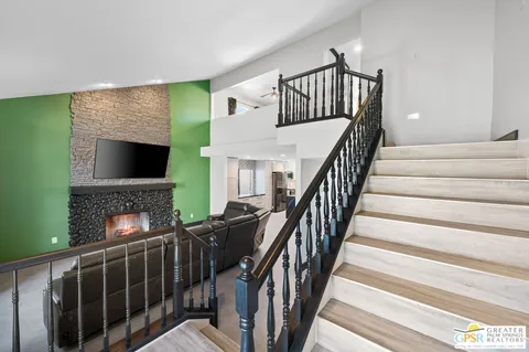 a view of staircase with wooden floor and a fireplace