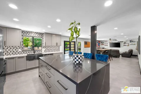 a kitchen with stainless steel appliances granite countertop a sink counter space and living room view