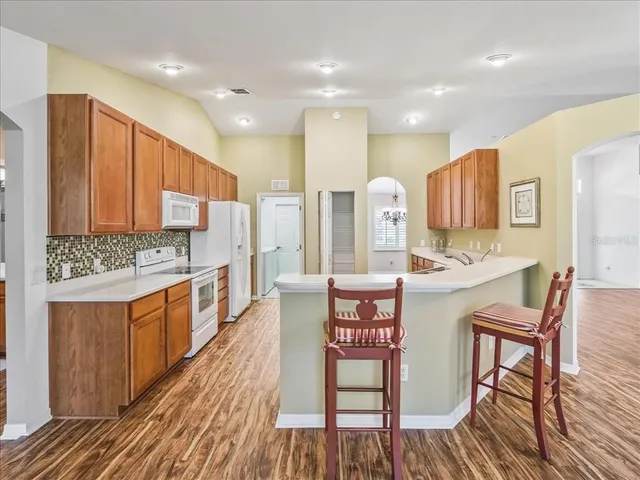 a large kitchen with stainless steel appliances kitchen island granite countertop a sink and cabinets