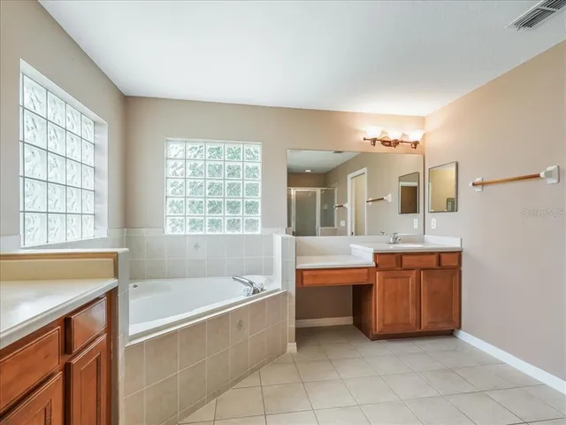 a spacious bathroom with a granite countertop tub sink and mirror