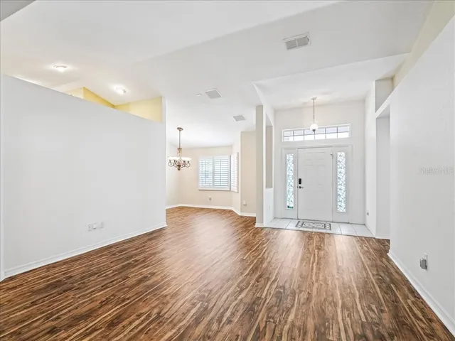 a view of an empty room with wooden floor