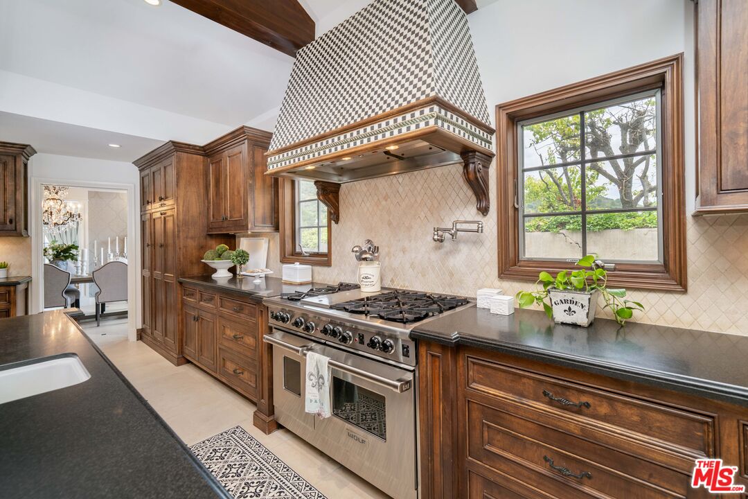 16632 Bienveneda Place Pacific Palisades, CA 90272 - Photo 19 of 62 a kitchen with stainless steel appliances a stove and cabinets
