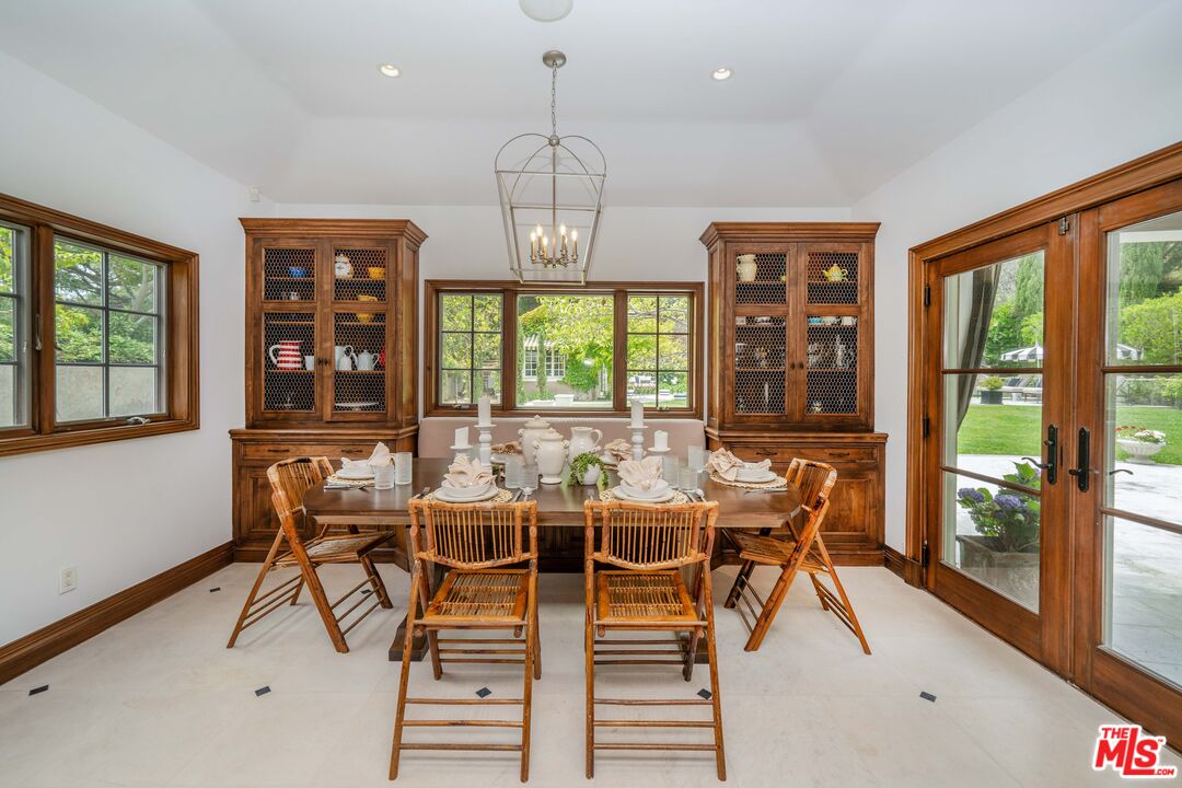 16632 Bienveneda Place Pacific Palisades, CA 90272 - Photo 20 of 62 a dining room with wooden floor a chandelier a glass table and chairs