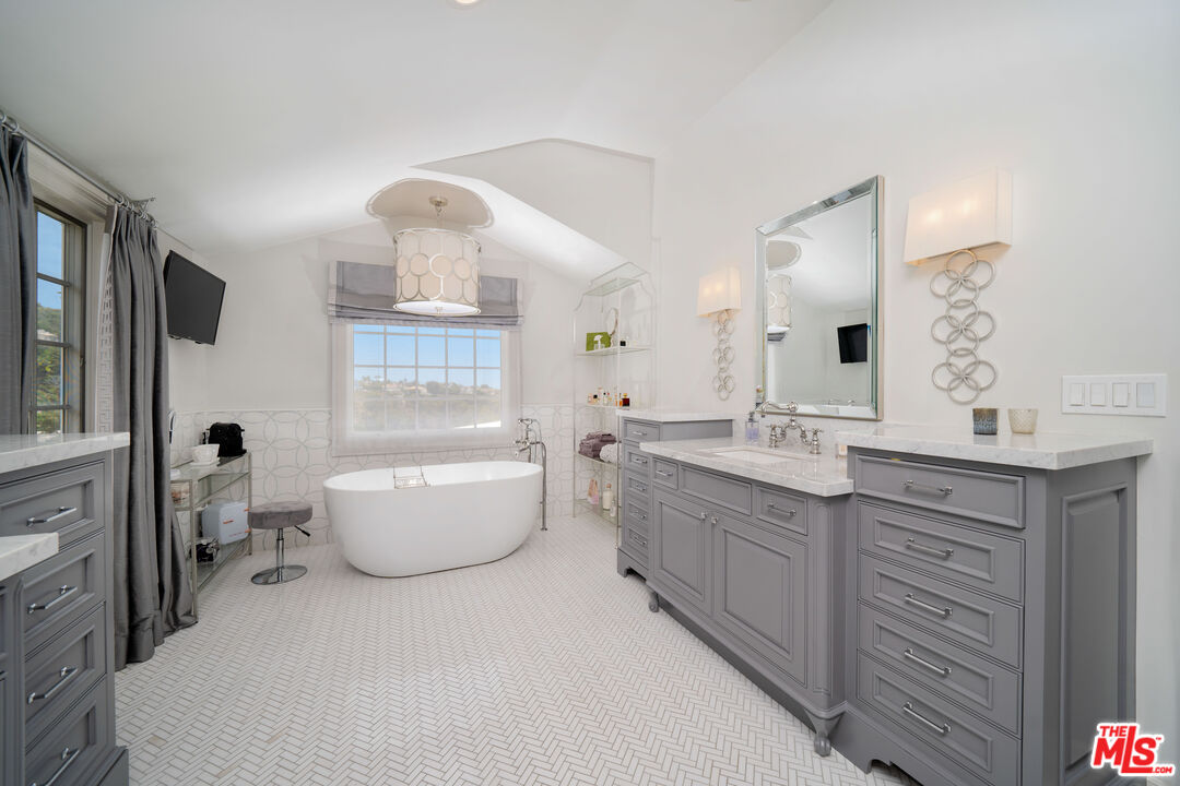 16632 Bienveneda Place Pacific Palisades, CA 90272 - Photo 30 of 62 a bathroom with a double vanity sink mirror and bathtub