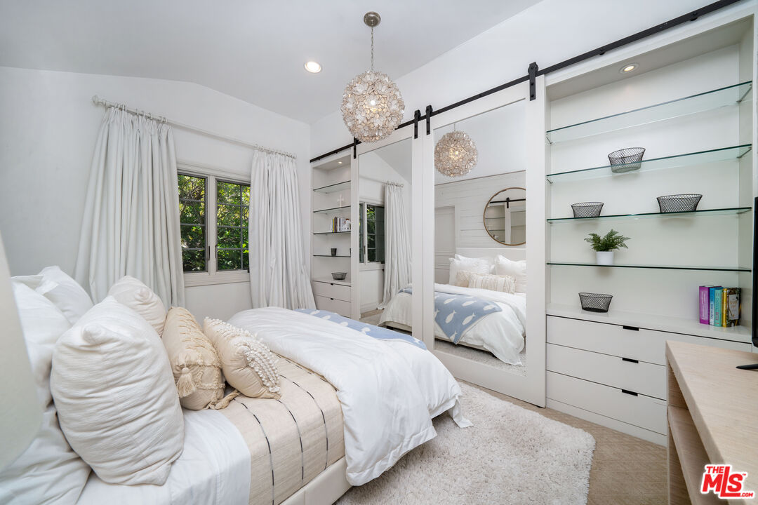16632 Bienveneda Place Pacific Palisades, CA 90272 - Photo 33 of 62 a bedroom with a large bed and a chandelier